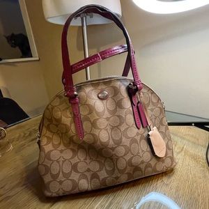 Tan monogram coach handbag with shoulder strap. Pie-loved wear on handles